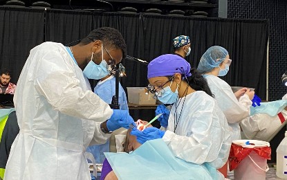 Bonsa Numera and Riana Joseph, fourth-year dental students, offer treatment to a patient at the Eastern Shore Mission of Mercy in Salisbury, Md. on Friday, Sept. 13.